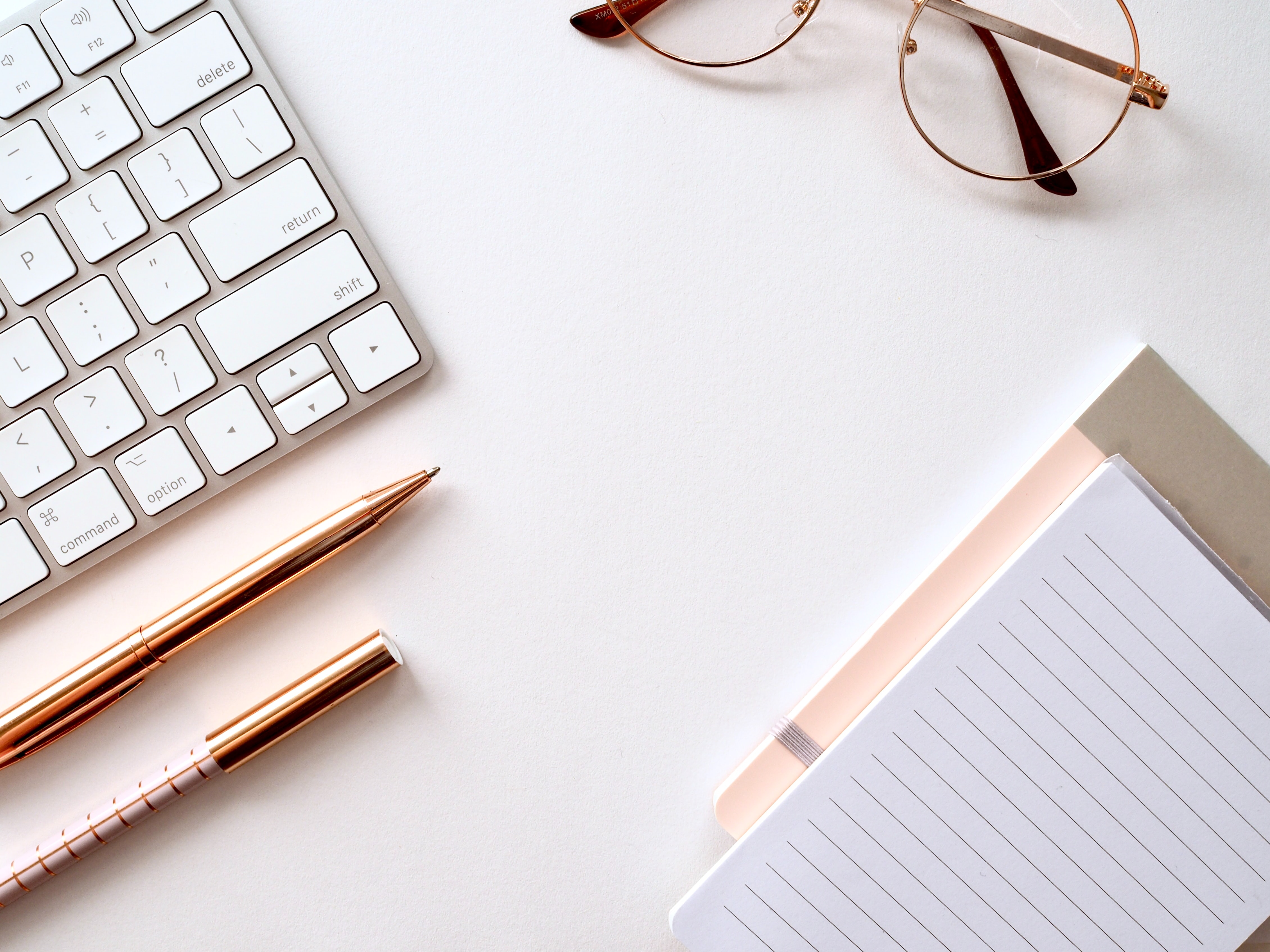 overhead image of desk containg keyboard, pencils, and eyeglasses